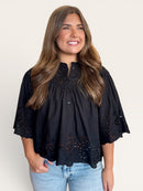 Black eyelet short sleeve top with delicate cutwork on sleeves, hem, and back